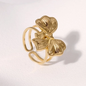 Minimalist gold bow and floral stainless steel open ring shown from a 45-degree angle view