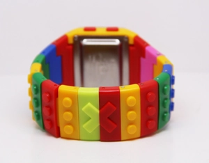 Macro view of building block style digital watch with colorful strap and metal back