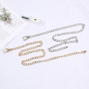 Flat lay of gold and silver metal chain belts with square buckles on white background