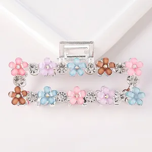 Large silver hair claw with colorful resin flowers and rhinestones on white background