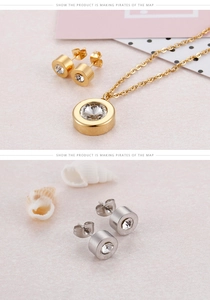 Detail of round solitaire jewelry set with polished gold necklace and cz stud earrings