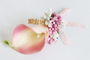 Detail of pink calla lily boutonniere with berries, silk ribbon and rhinestone ring