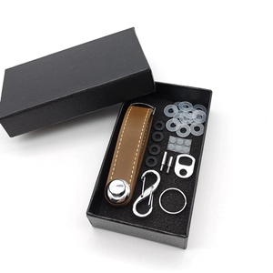 Detailed set of brown leather key organizer with metal rings and screws in a gift box