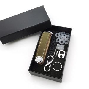 Detailed view of green leather key organizer kit with metal accessories in black gift box