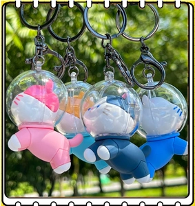Close-up of four colorful silicone astronaut cat keychains in outdoor settings