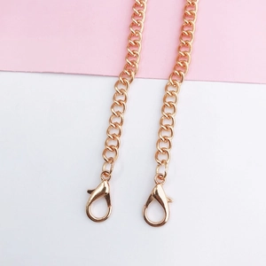 Detailed close-up of rose gold metal crossbody chain straps with secure lobster clasps