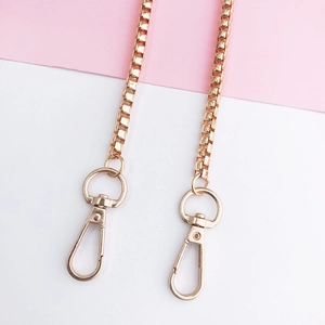 Close-up of rose gold metal box chain strap with swivel lobster clasps for bags