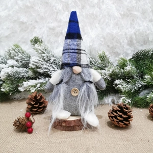 Macro detail of Nordic Christmas gnome featuring blue plaid hat and gray felt body