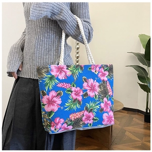 Blue canvas tote bag with pink hibiscus floral print and white rope shoulder straps