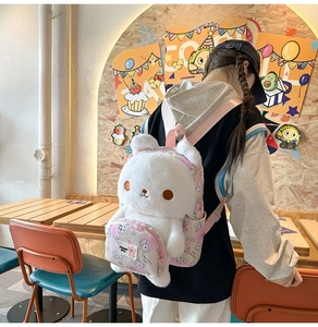 Detail of cute white rabbit plush backpack featuring soft ears and pink adjustable straps