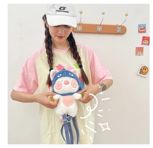 Detail of cute cat plush toy wearing blue shark hoodie with adjustable nylon strap