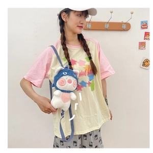 Detailed view of the cute blue plush cat crossbody bag worn over a casual graphic t-shirt