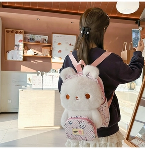 Detail of cute white plush bunny backpack featuring 3D ears and pink straps for girls