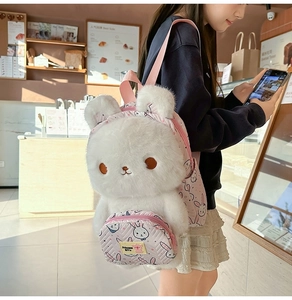 Detail view of white plush rabbit backpack with pink straps on a female model