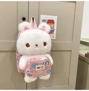 Detail of white plush rabbit backpack with pink front pocket and cute cartoon bunny patterns