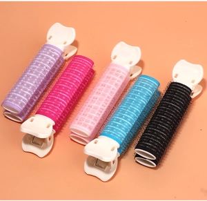 Detail shot of five colorful hair volumizing clips on an orange background for styling