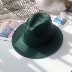 Detailed view of a dark green wool fedora hat with a classic crown and flat brim
