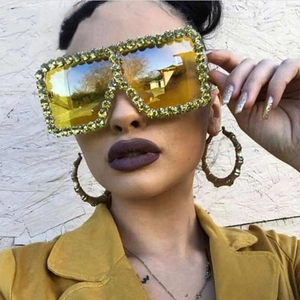 Detail of oversized square sunglasses with sparkling rhinestones and yellow tinted lenses