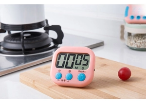 Pink kitchen timer on wooden board showing LCD display for cooking and study