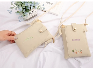 Detailed view of mini PU leather phone bags with leaf and cactus prints on white surface
