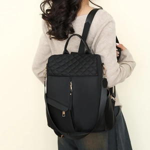 Women's black nylon backpack with quilted diamond stitching and gold-tone zippers