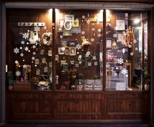 Detail view of various white snowflake static stickers on a glass store window display