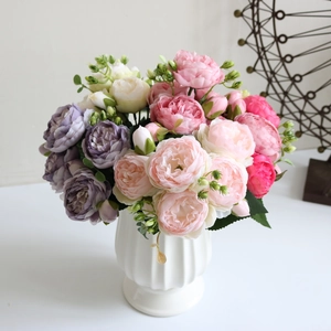 Detail of silk peonies and roses in a white ceramic vase for elegant home decor