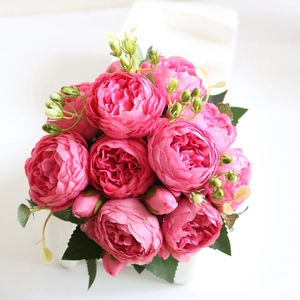 Macro detail of vibrant pink silk peonies with green leaves and delicate buds