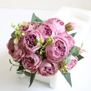 Close-up of pink-purple artificial peony bouquet with realistic petals and green buds