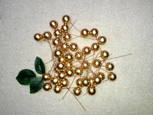 Detail of 15mm golden artificial berries with green leaves for DIY Christmas tree decoration