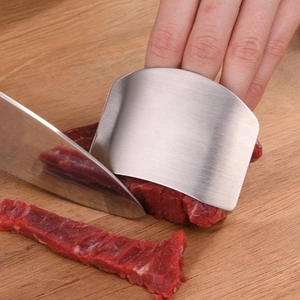 Stainless steel finger guard for cutting meat on wooden board in kitchen setting