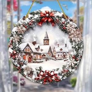 Close-up of a Christmas ornament with snow scene building and festive pine wreath