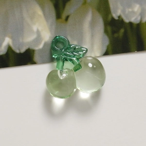 Macro shot of translucent light green acrylic cherry pendants for DIY jewelry making