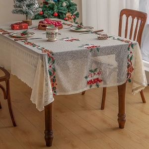Close-up of Christmas tablecloth featuring festive embroidery and delicate lace edges