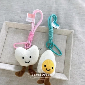 Portachiavi in peluche a cuore e uovo fritto con moschettoni colorati su vassoio
