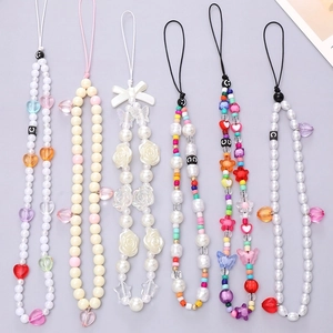 Flat lay of colorful rhinestone chain phone lanyards with acrylic heart and flower beads