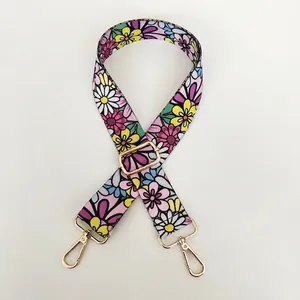 Detail of adjustable floral embroidered bag strap with premium gold metal swivel hooks