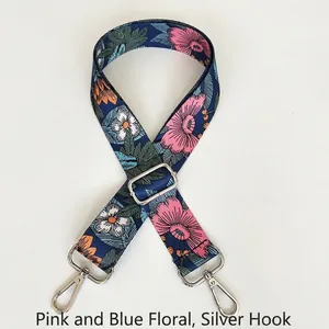 Close-up of adjustable pink and blue floral crossbody bag strap with silver metal hooks