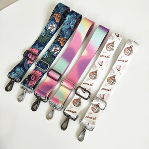 Detail view of colorful patterned bag straps with adjustable metal buckles and spring hooks