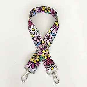 Detail view of ethnic floral embroidered bag strap with adjustable silver metal hooks