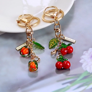 Cute fruit-shaped cherry and persimmon keychains with handmade tags and golden hardware