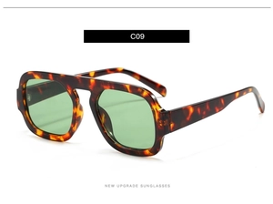 Detail of tortoiseshell frame and green lens on classic pilot style sunglasses