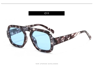 Detailed close-up of tortoise shell frame sunglasses with light blue transparent lenses