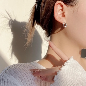 Elegant S925 sterling silver hollow teardrop earrings for women worn in sunlight
