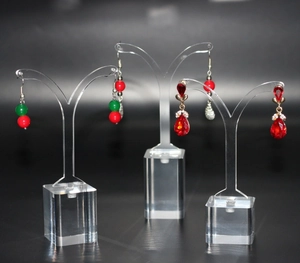Detailed close-up of beaded and gemstone earrings on transparent acrylic jewelry stands