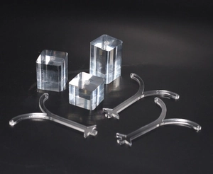 Detailed view of clear acrylic earring display stands and pedestals on a black background