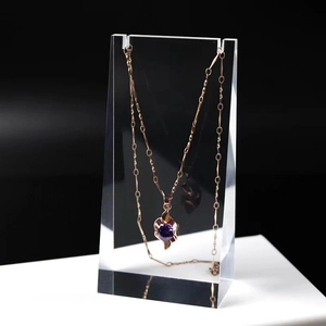 Detail of rose gold necklace with purple gemstone pendant on acrylic display stand