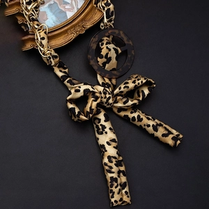 Fashionable leopard print waist belt with golden metal chains and elegant ribbon bow