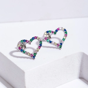Fashionable heart-shaped stud earrings with colorful zircon stones on a white stand