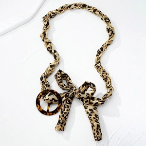 Fashionable leopard print belt with gold chain weave and round tortoiseshell buckle